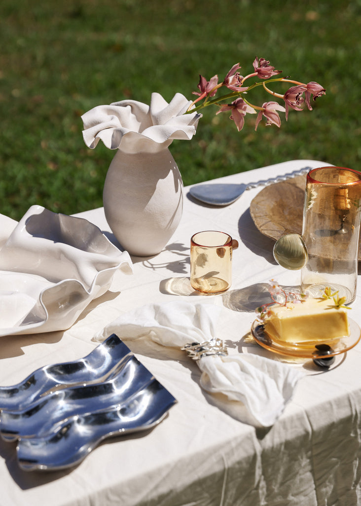 Curated table with vase and artisanal artful vintage pieces and glassware
