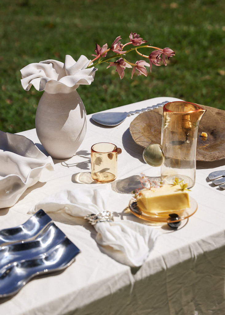 Curated table with vase and artisanal artful vintage pieces and glassware